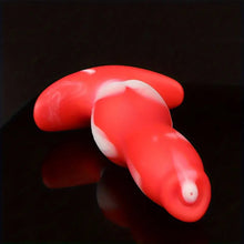 Load image into Gallery viewer, A red and white ombre dog penis anal plug sex toy laying down on a black shiny bench.